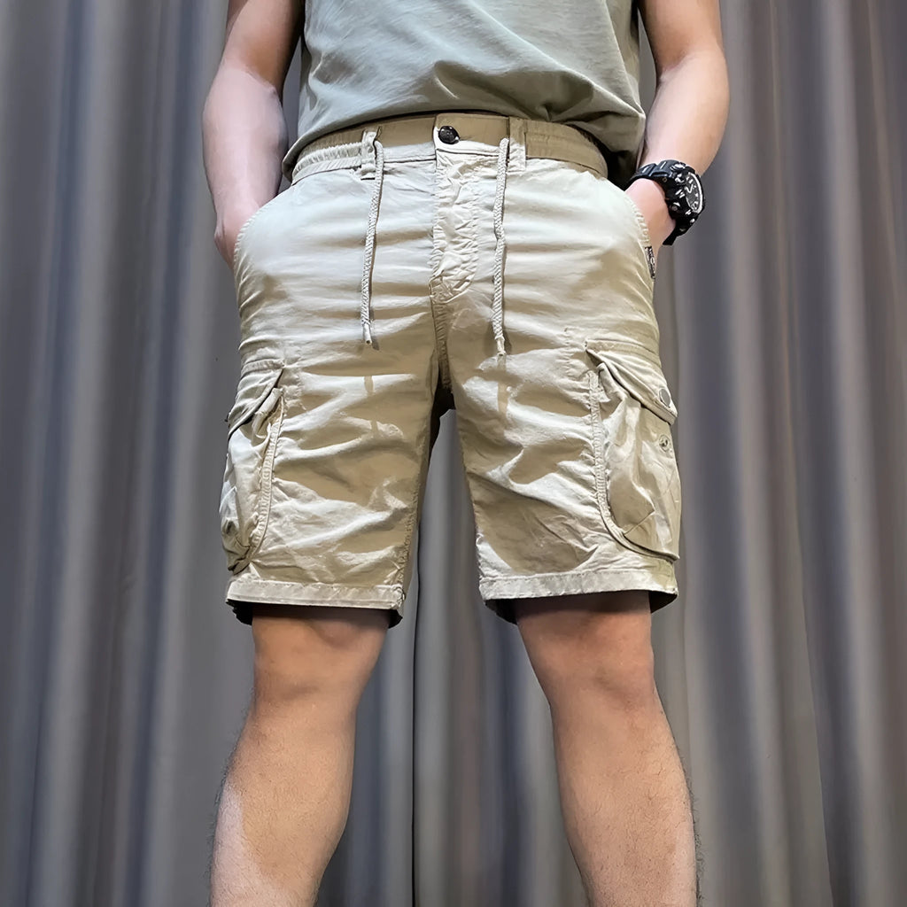 A pair of loose-fitting straight leg casual overalls in khaki colour with multiple pockets, shown laid flat.