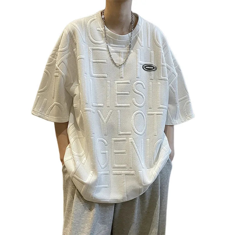 Grey men's loose t-shirt with a raised white 3D letter graphic on the chest.