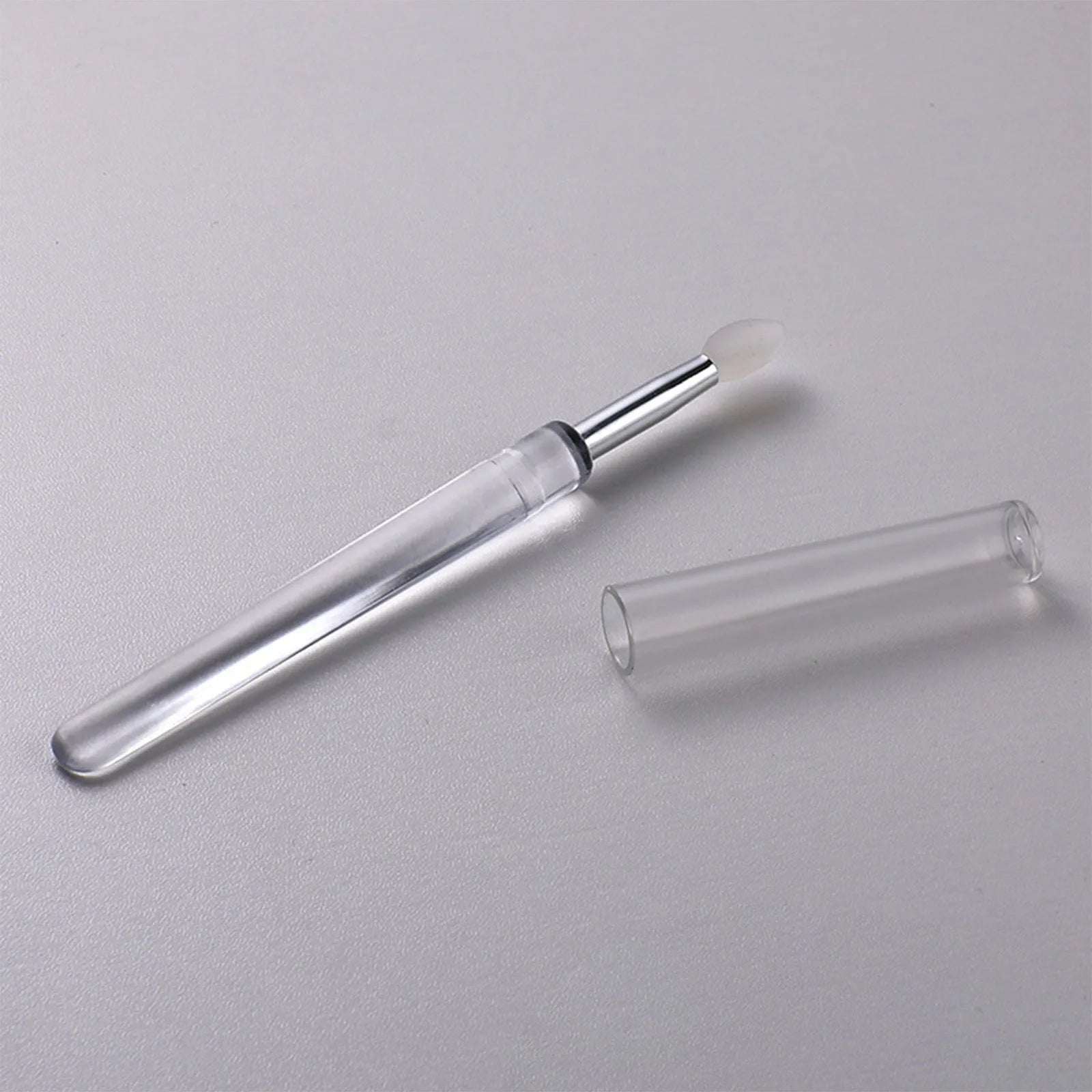 Set of four reusable silicone lip brushes with caps in assorted colours.