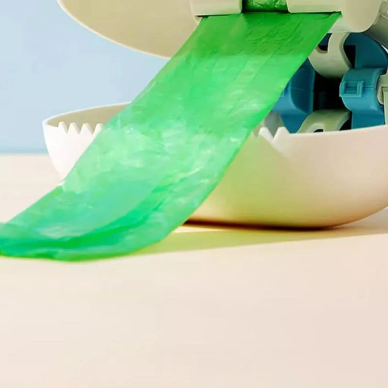 White blue dog pooper scooper with cloud-shaped jaw design on grass