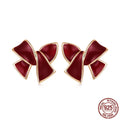 Pair of silver 925 sterling silver bow stud earrings with wine red finish on white background