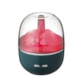 Green ultrasonic humidifier with colourful gradient light on desk showing heavy mist output