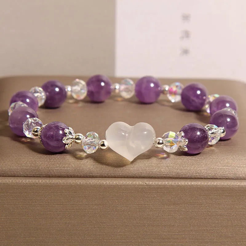 Natural amethyst bracelet with white agate love heart charm on a light background