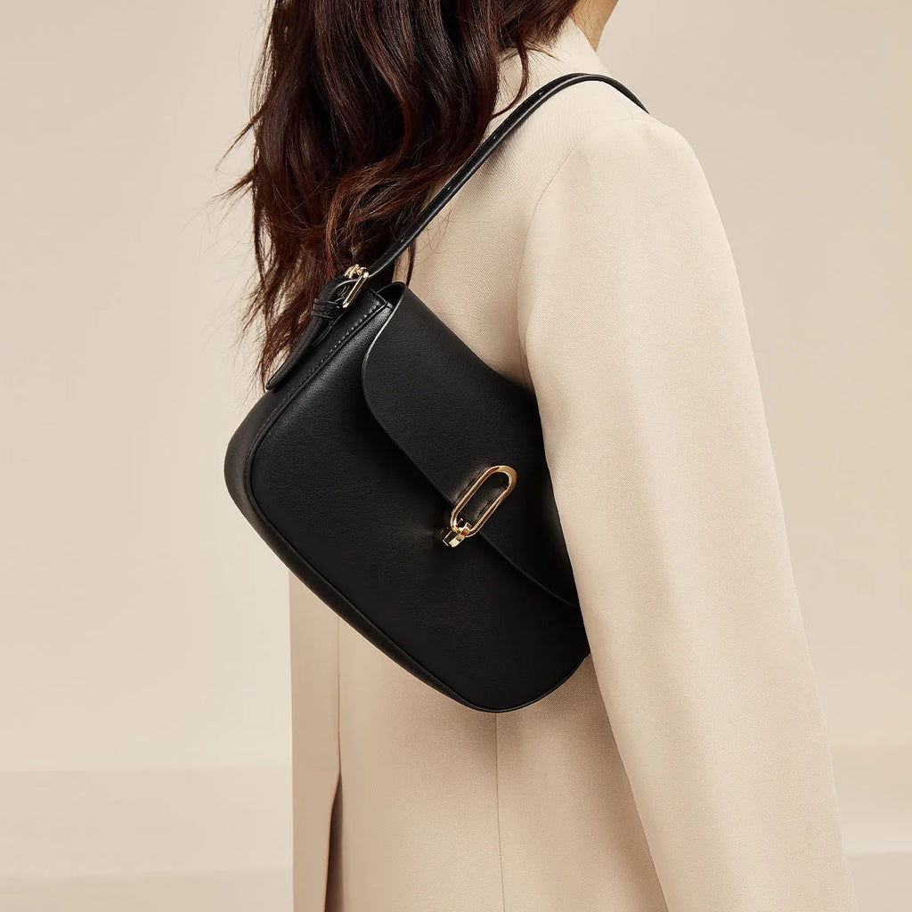 Black square leather messenger bag with shoulder strap showing lock closure and urban design