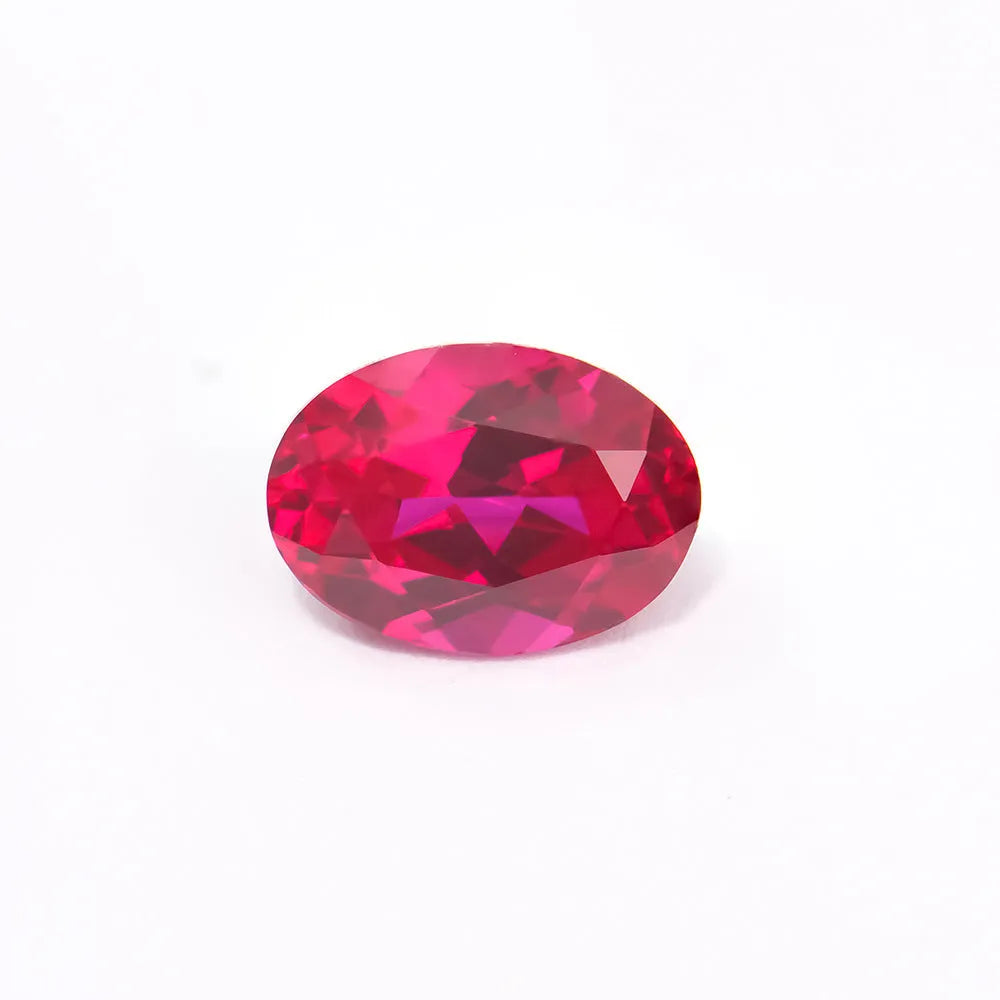 A loose, artificial pigeon blood red ruby gemstone showing a brilliant round cut on a neutral background.