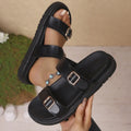 Women's black microfiber buckle strappy beach sandals with thick rubber sole on a surface