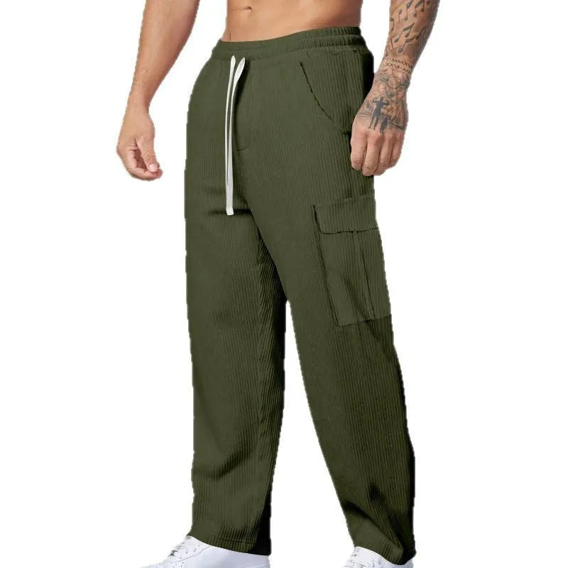 Man wearing loose-fitting straight-leg corduroy cargo trousers in navy blue with a drawstring waist.