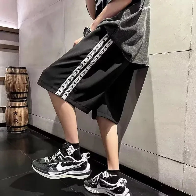 Man wearing loose black track pants with a sporty style, showing the baggy fit and micro elastic fabric.