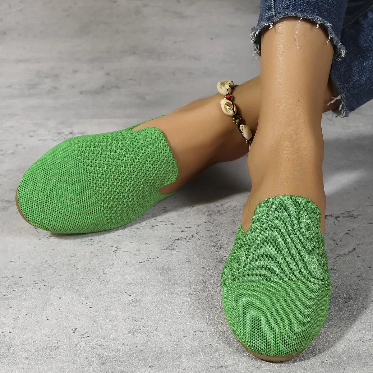 Apricot coloured mesh slip-on sandals with round toe, cloth upper, and flat rubber sole.