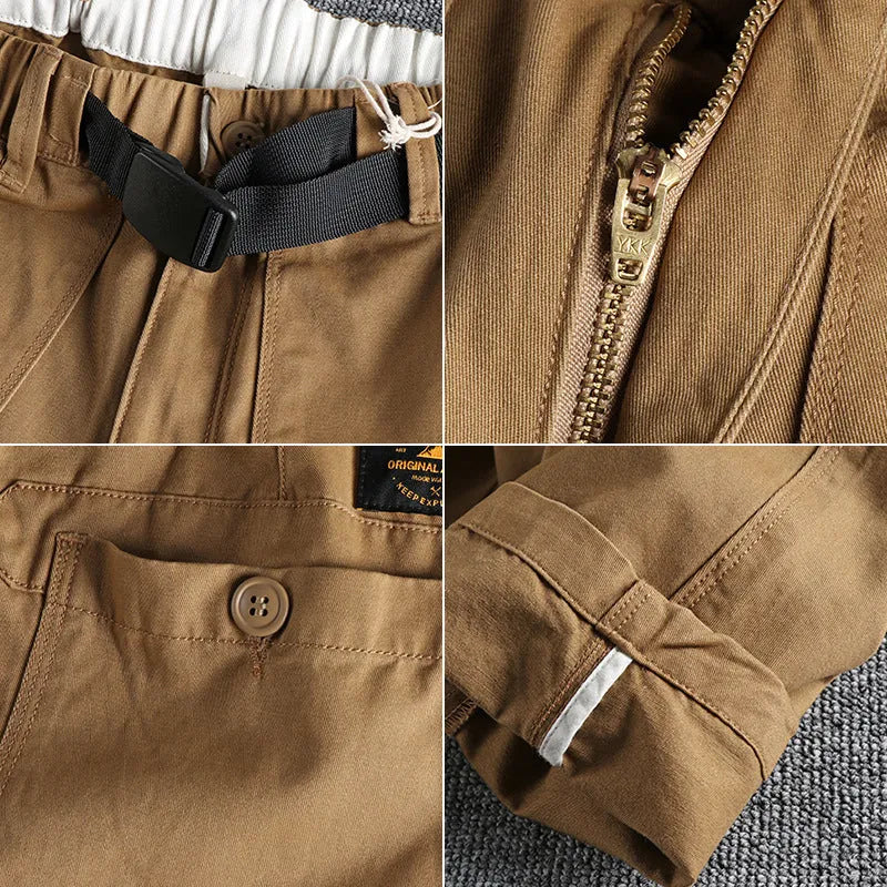 Men's khaki cotton work trousers with a buckle belt and three-dimensional cut on a hanger.