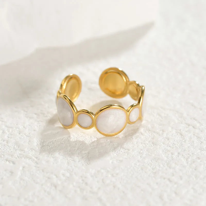 A stainless steel geometric ring with an adjustable opening on a plain background.