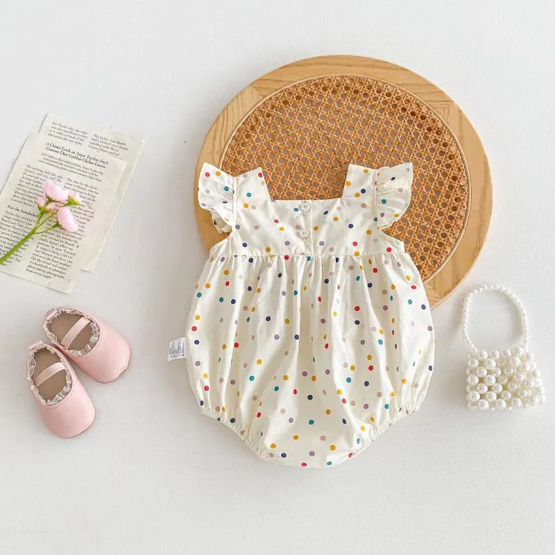Beige cotton newborn summer jumpsuit with polka dots and flounced sleeves on white background
