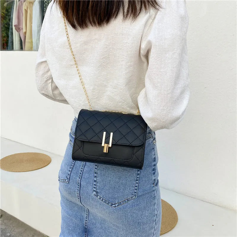 Women's black PU leather crossbody bag with diamond lattice chain detail and adjustable shoulder strap