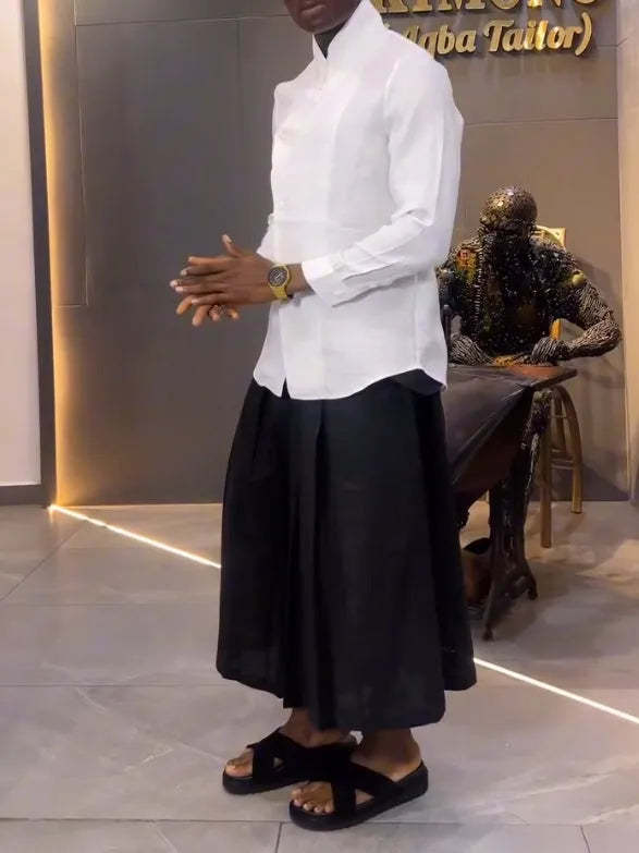 White asymmetric front long sleeve shirt paired with black pleated pants in a women's casual co-ord set.