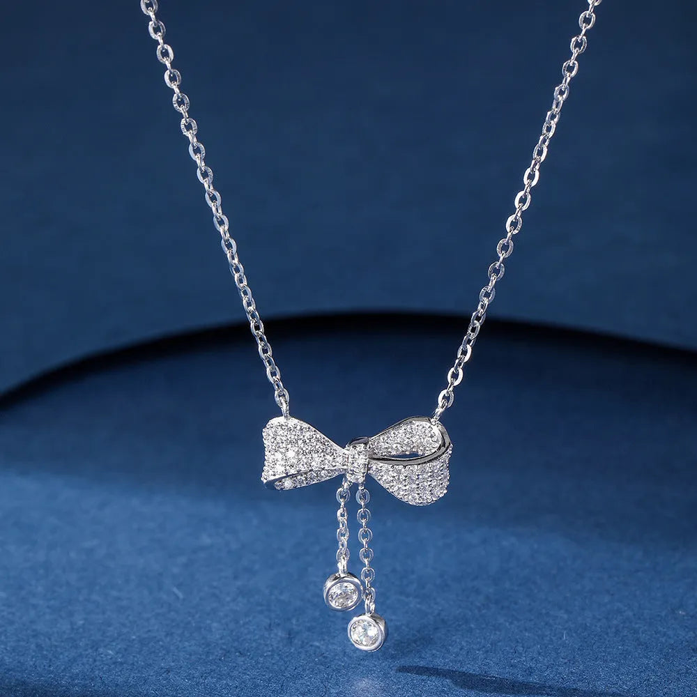 S925 sterling silver necklace with bow pendant on an O-ring chain, shown at clavicle length.