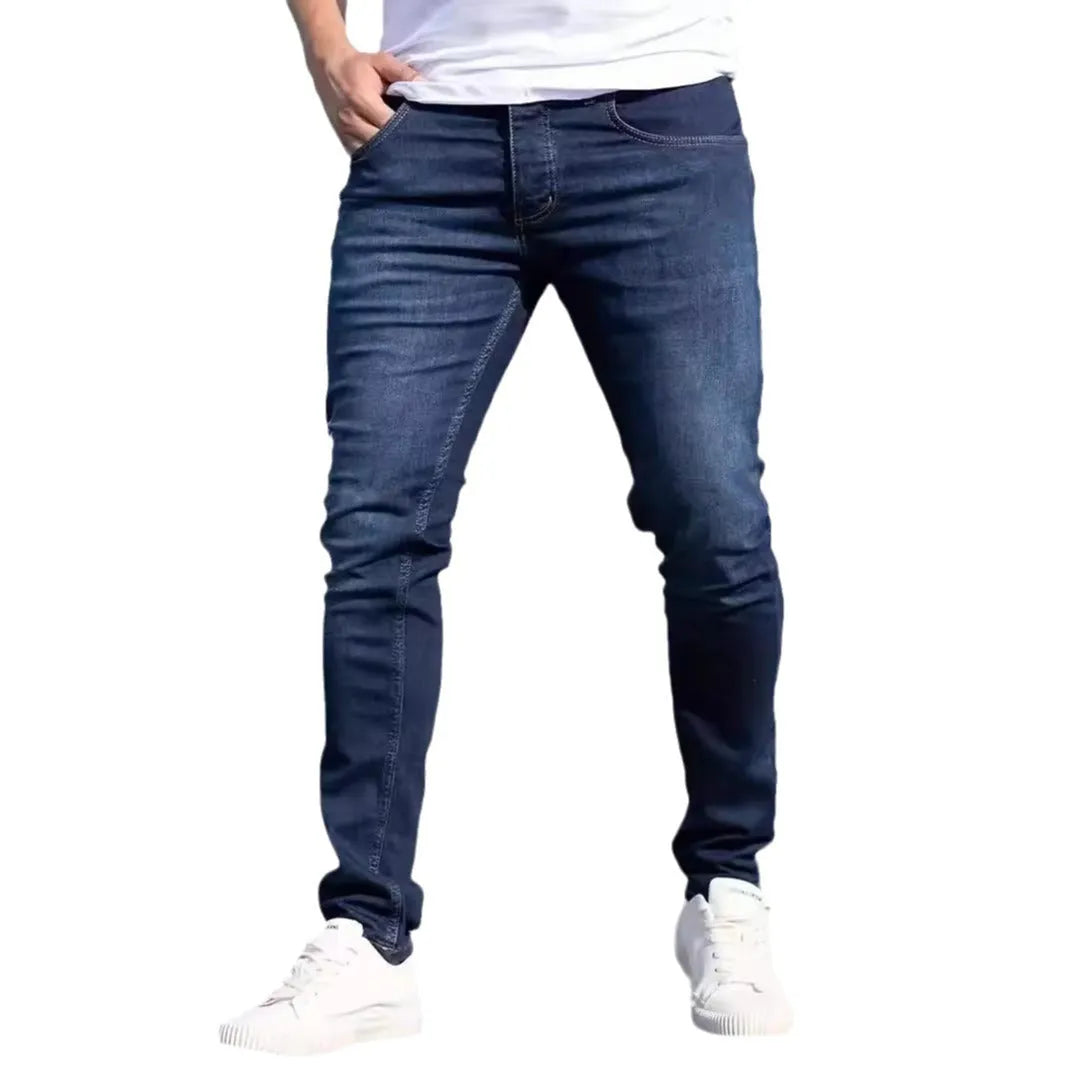 Men's dark blue slim fit cotton jeans showing skinny leg silhouette and street fashion style