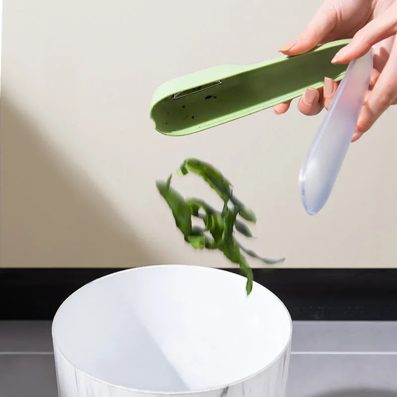 Dark green kitchen peeler with storage tube and stainless steel blade for fruit and vegetable peeling