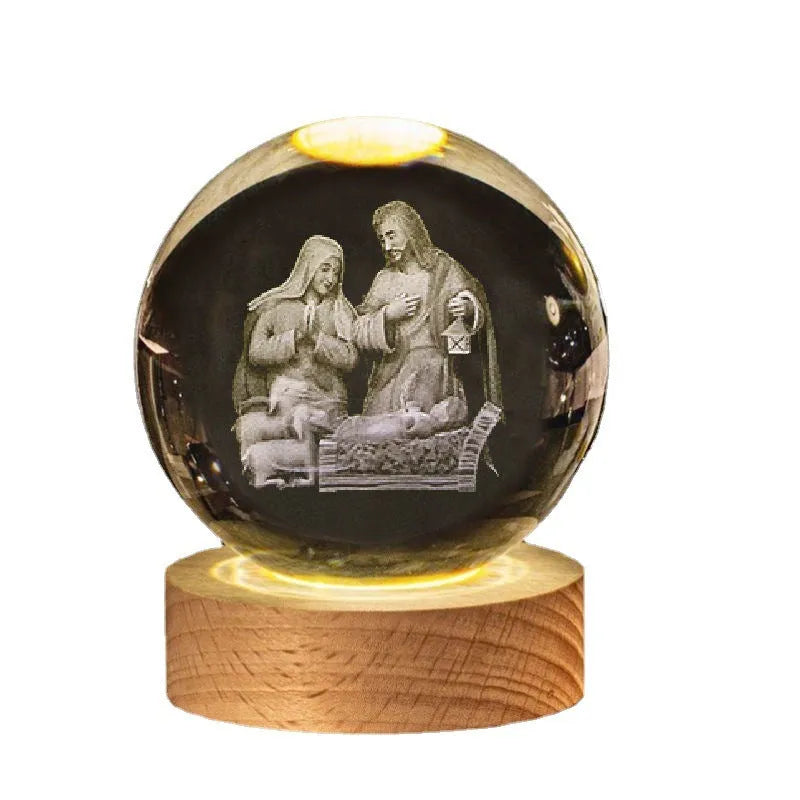 White crystal ball ornament on a wooden warm light base, showing engraved religious symbols.