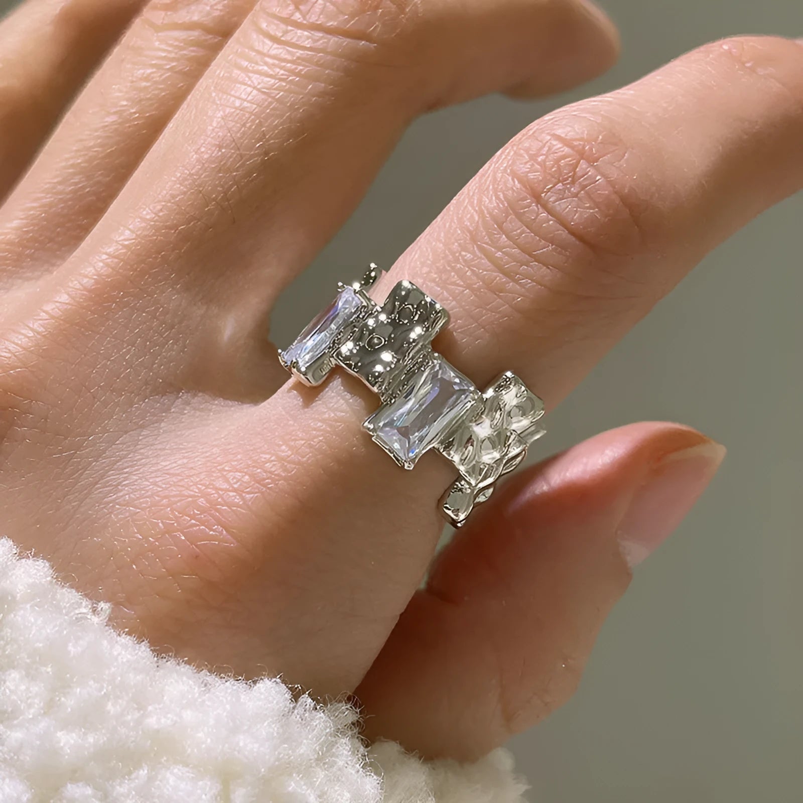 Silver plated open ring with a cross design and zircon gemstones in a geometric shape.