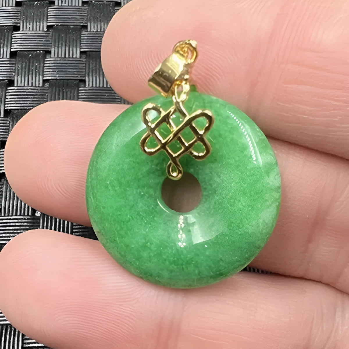 Dry green jade coin buckle pendant 25mm diameter on a light background