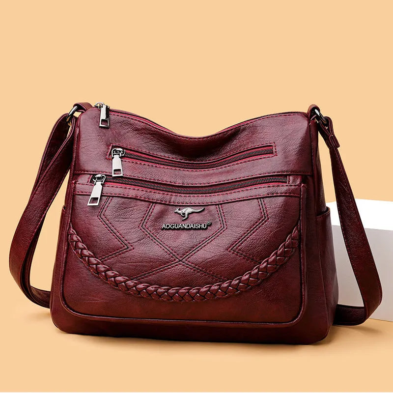 Soft PU leather women's shoulder bag in black colour showing crossbody strap and exterior pockets