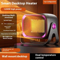 Grey compact desktop ceramic electric heater with rotatable body on a wooden desk.