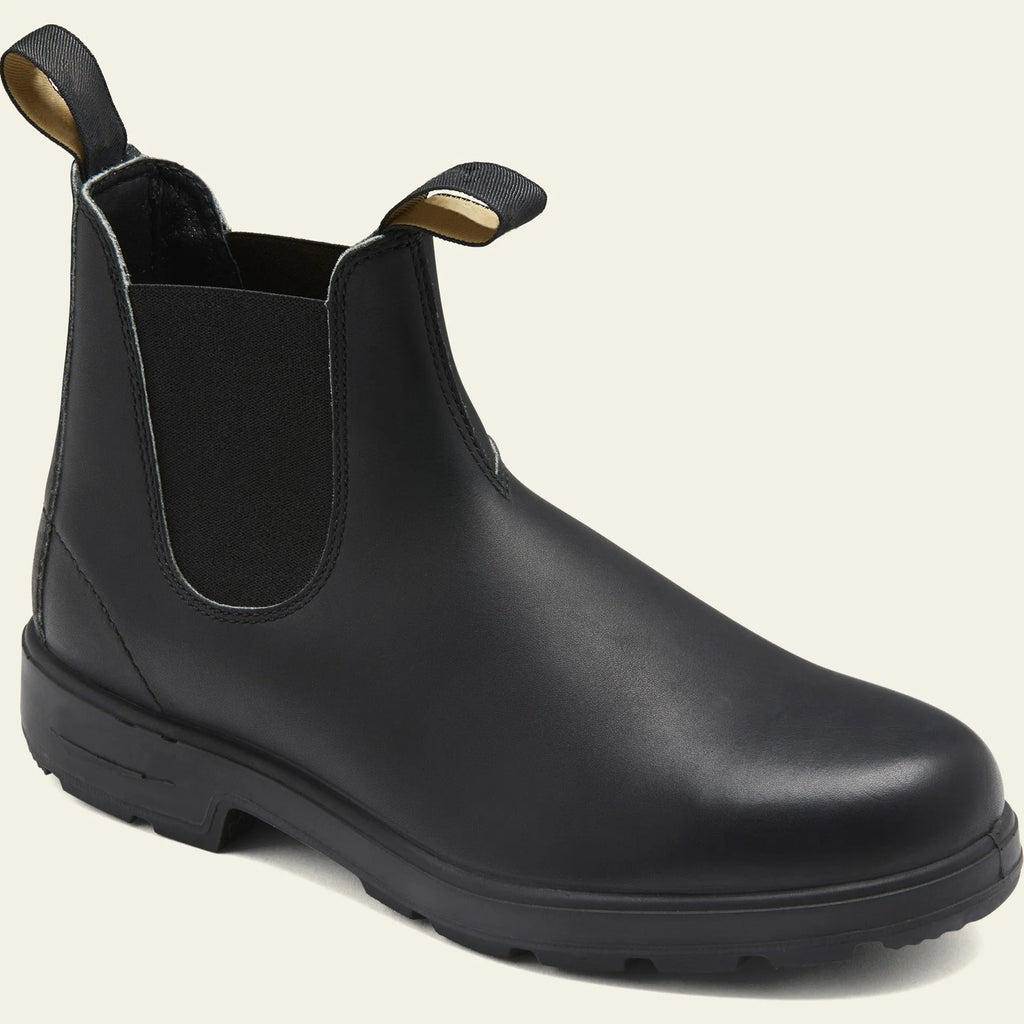 Vintage brown Chelsea boots with frosted PU upper and round toe on wooden floor