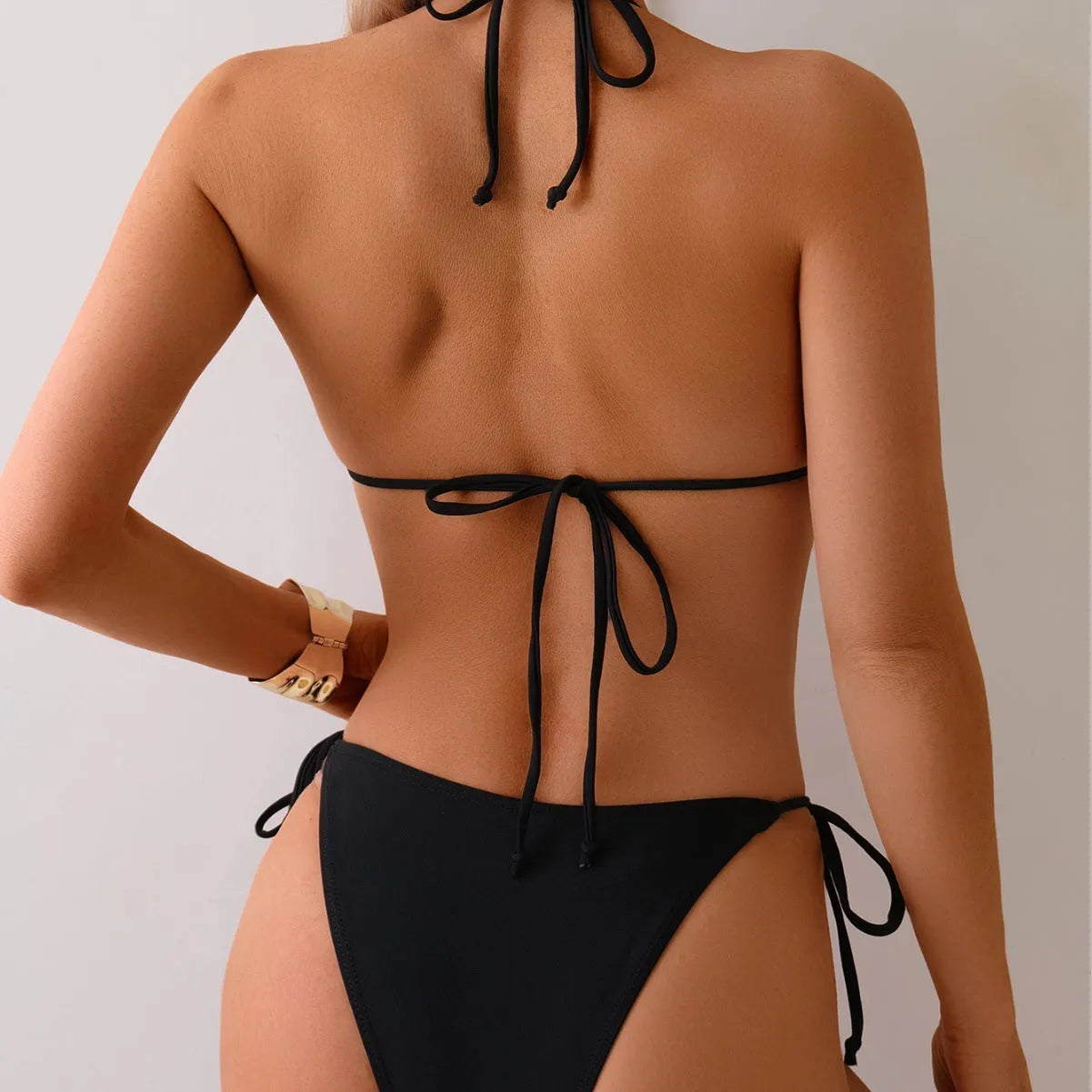 Black women's bikini swimsuit with metallic bead detail and split-front design