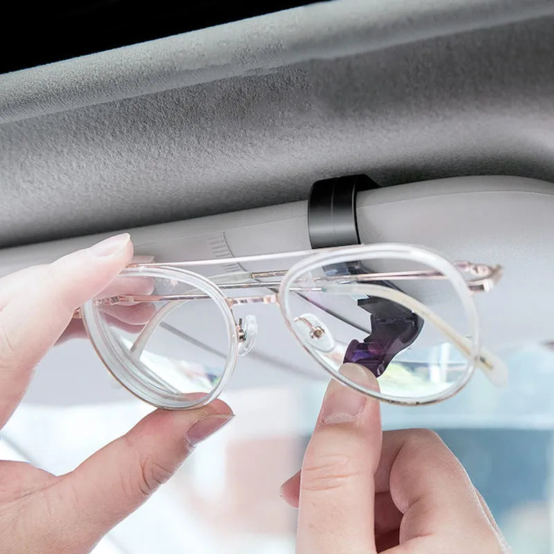Black plastic clip for car sunshade to hold sunglasses and cards, dimensions 6.5 by 2.3 cm.