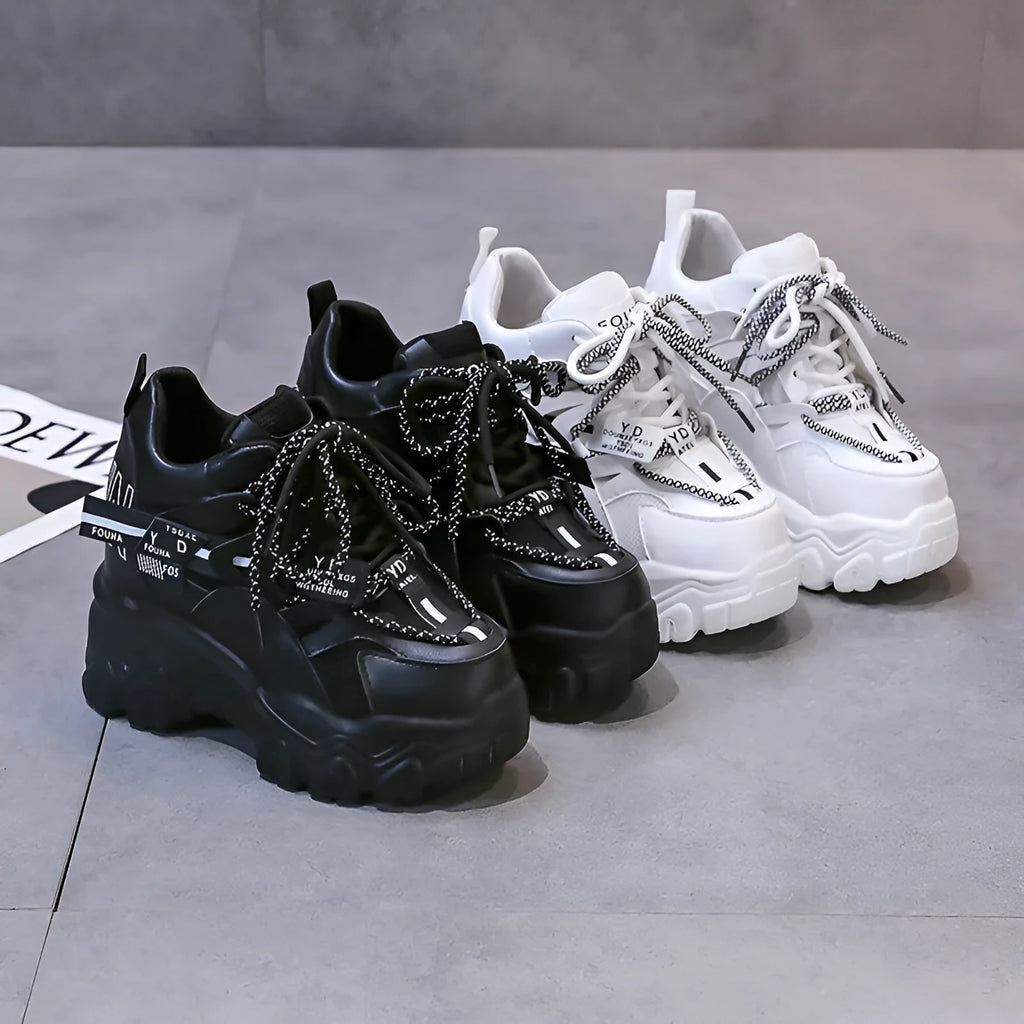 Women's white and black mesh platform sports shoes with cross strap and rubber sole.