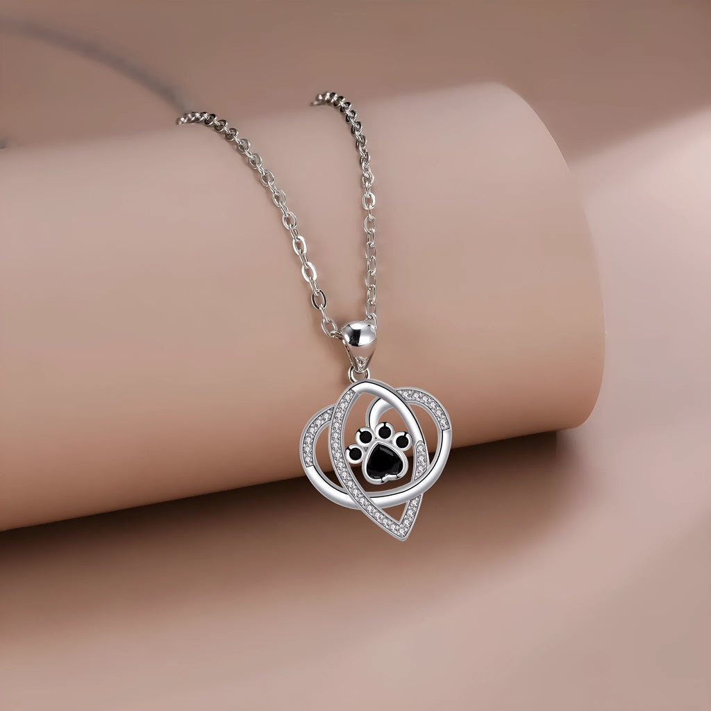 Women's copper necklace with dog and cat paw print pendant on cross chain.