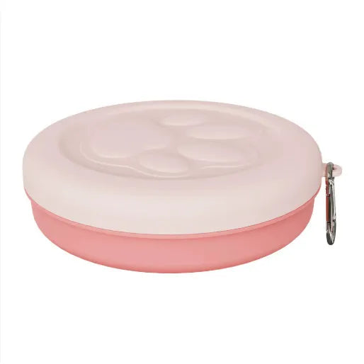 Collapsed and open views of a pink and green silicone portable dog bowl on a grassy background.