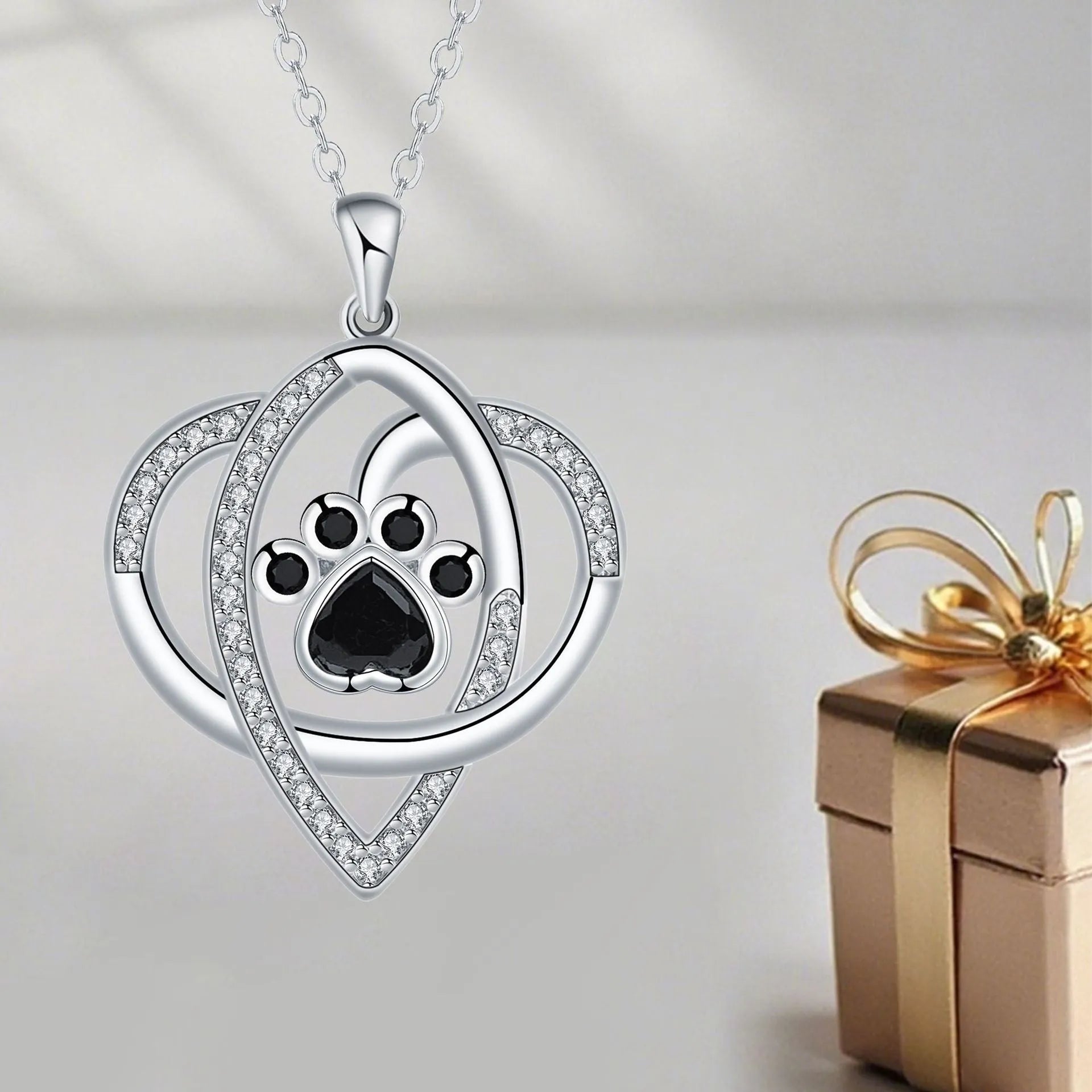 Women's copper necklace with dog and cat paw print pendant on cross chain.