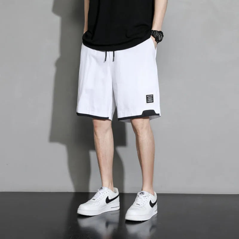 Boys' black cotton casual shorts with mid-waist, shown on a hanger.
