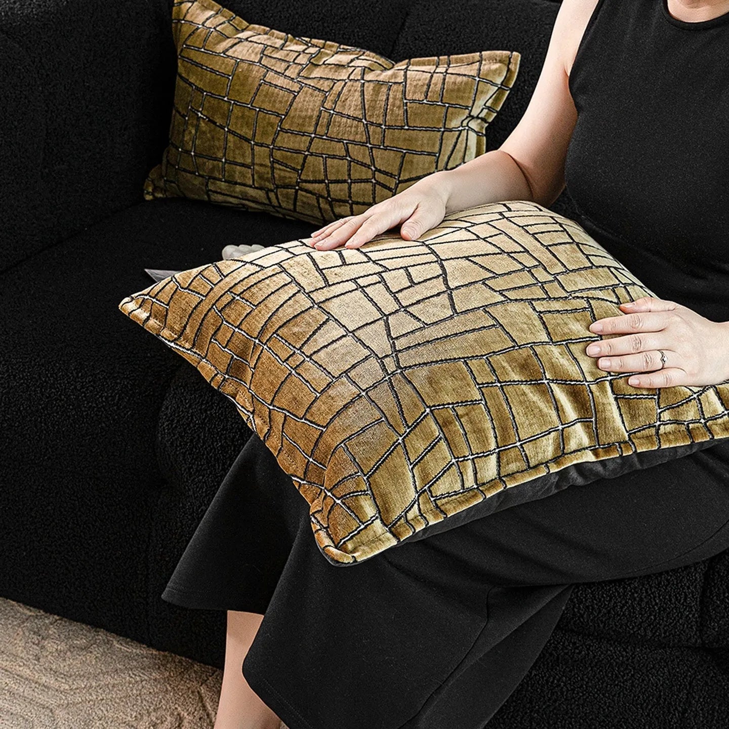 Gold geometric patterned decorative pillow on a grey sofa.