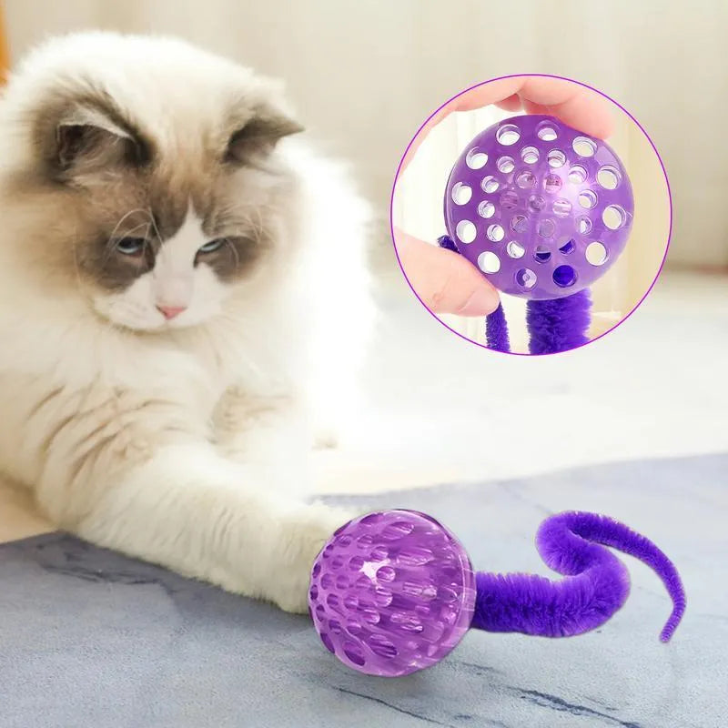 Interactive cat ball toy with elastic worm tail in green colour on wooden floor