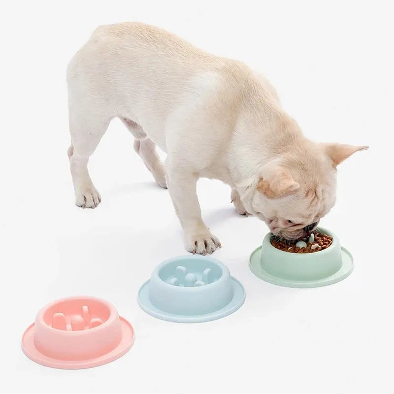 Pink pet slow feeder bowl with raised maze pattern and non-slip base on a floor