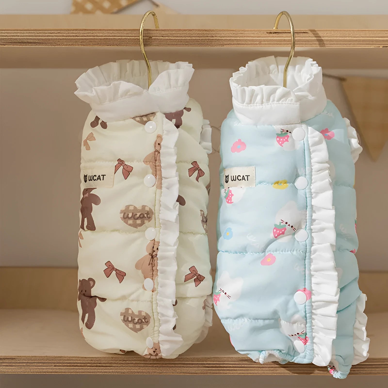 Small dog wearing cream fleece jumpsuit with bear pattern and white ruffles