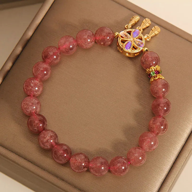 Natural strawberry quartz bracelet for women with a four-leaf dream catcher ball pendant on an elastic cord.