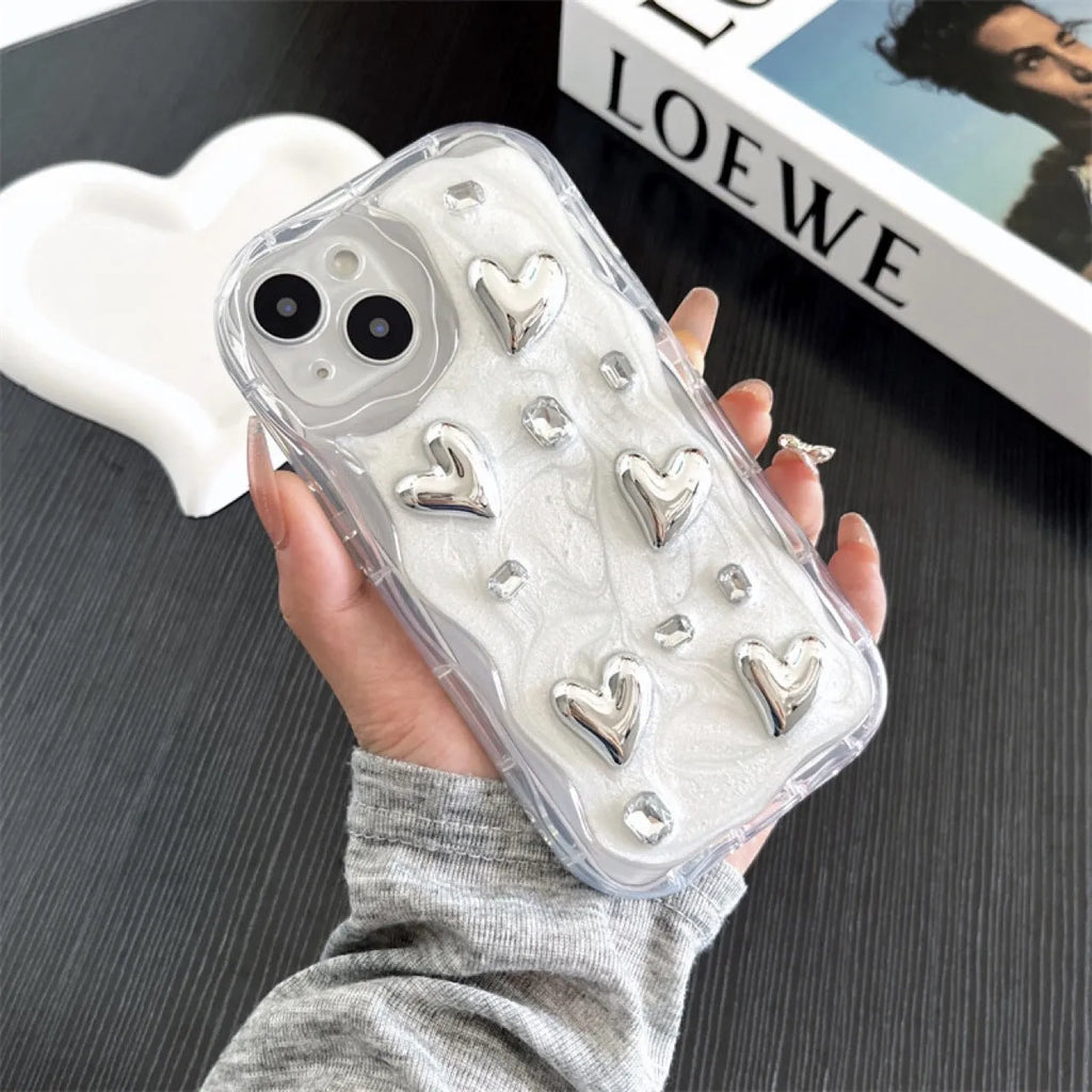 Transparent TPU phone case with three-dimensional silver love gem rhinestone heart design on white background