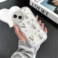 Transparent TPU phone case with three-dimensional silver love gem rhinestone heart design on white background