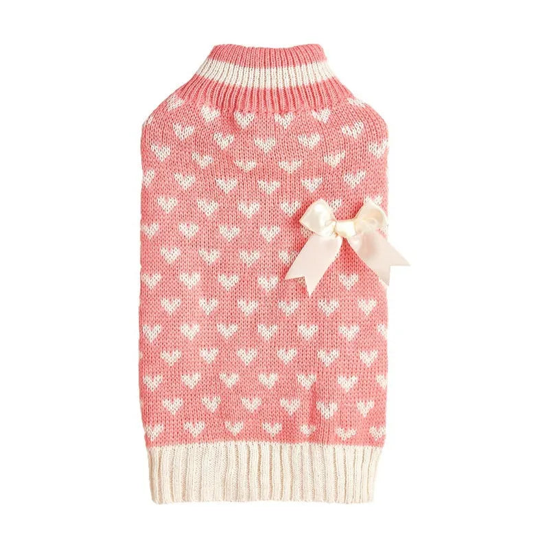 Red knitted dog jumper with a white love heart and bow design on a small dog