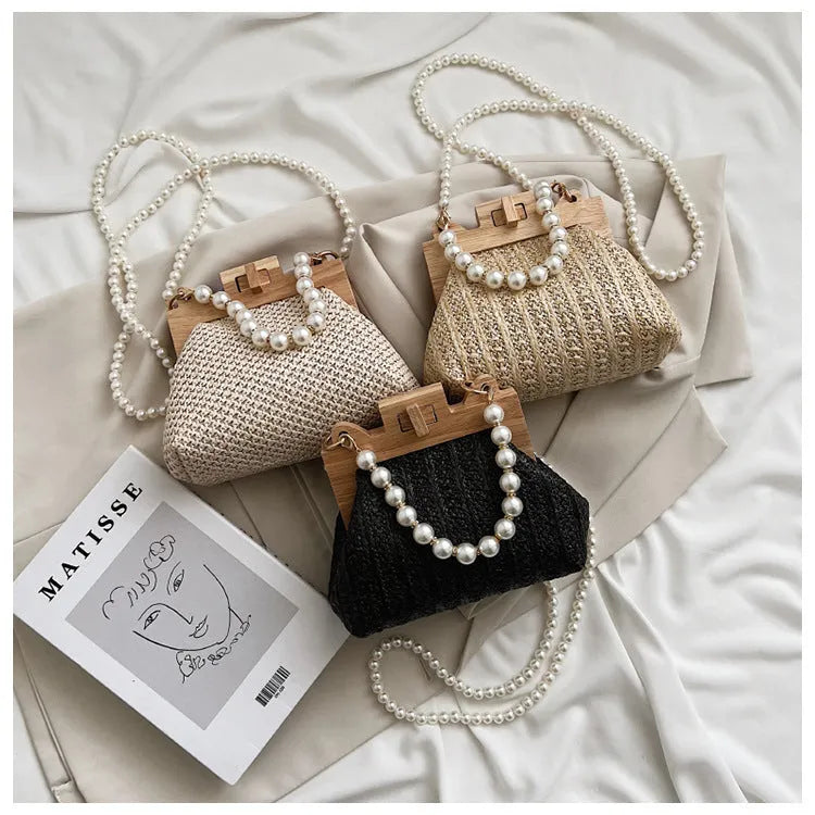 Women's straw woven shoulder bag with pearl chain strap and multiple internal compartments in horizontal square shape