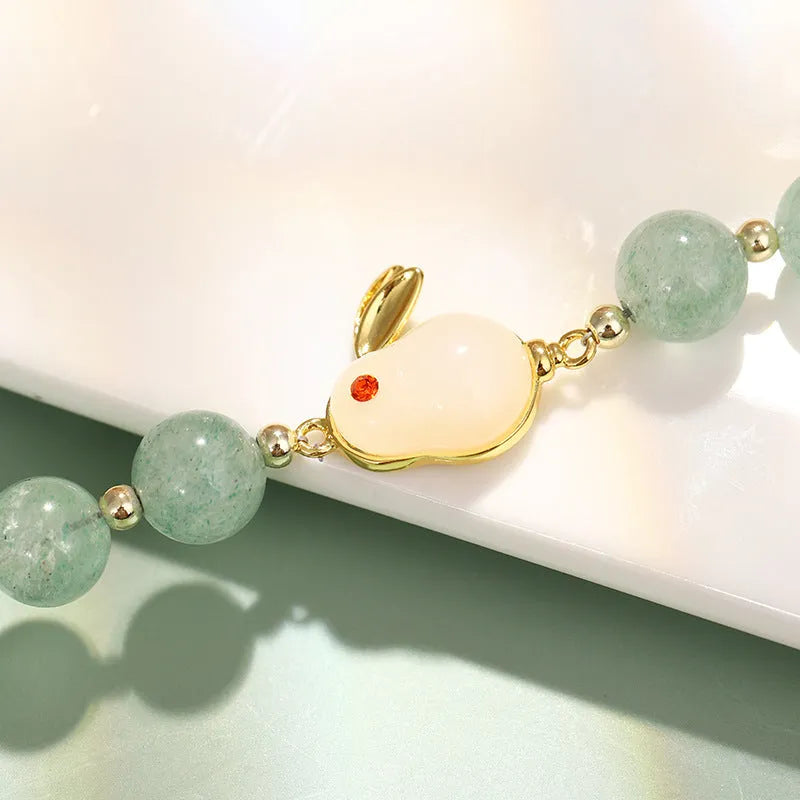 Rabbit charm bracelet with green natural stone beads and gold accents on adjustable chain