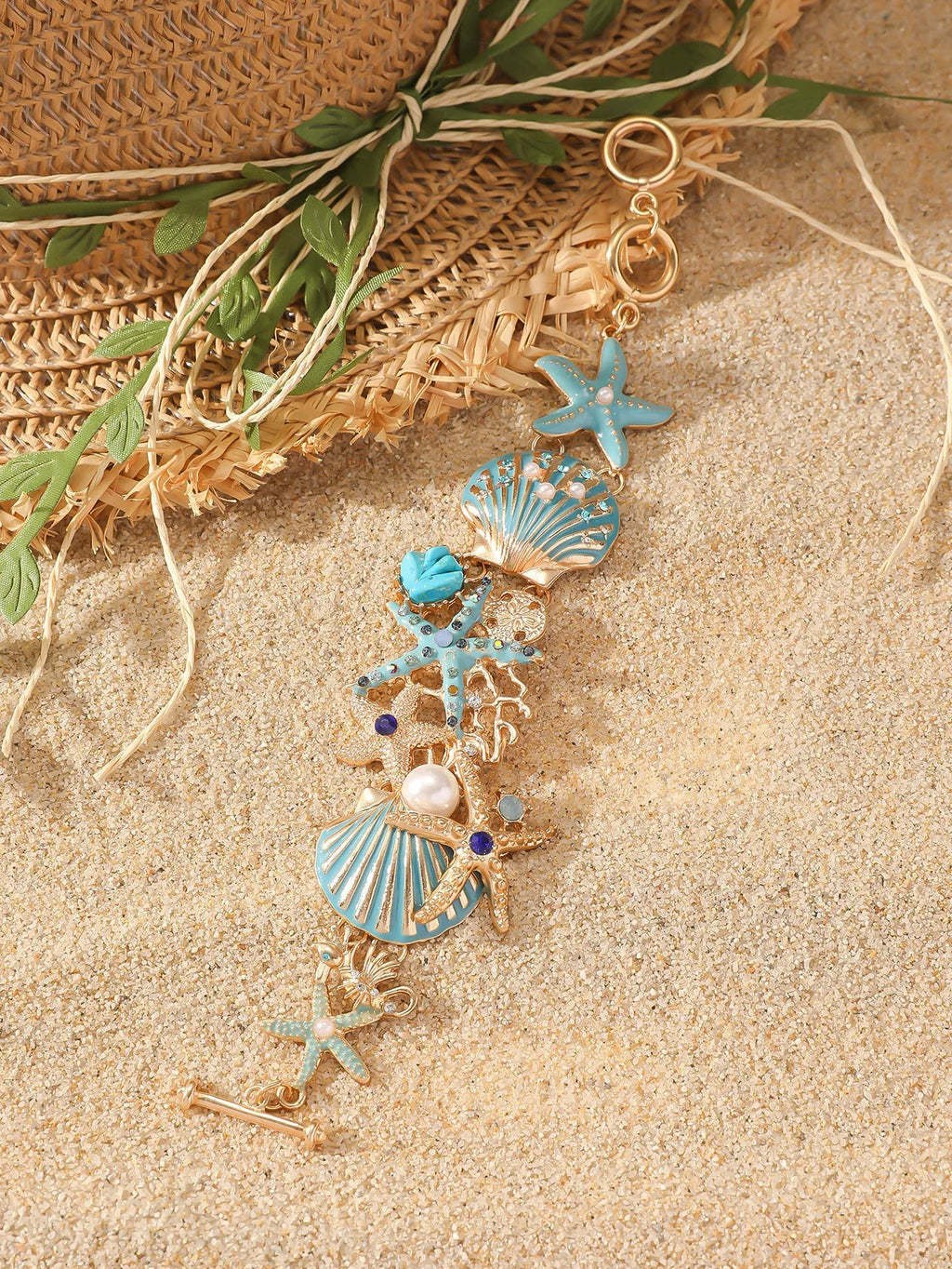 Alloy rhinestone bracelet with boat anchor and starfish charm in turquoise, red, or blue.