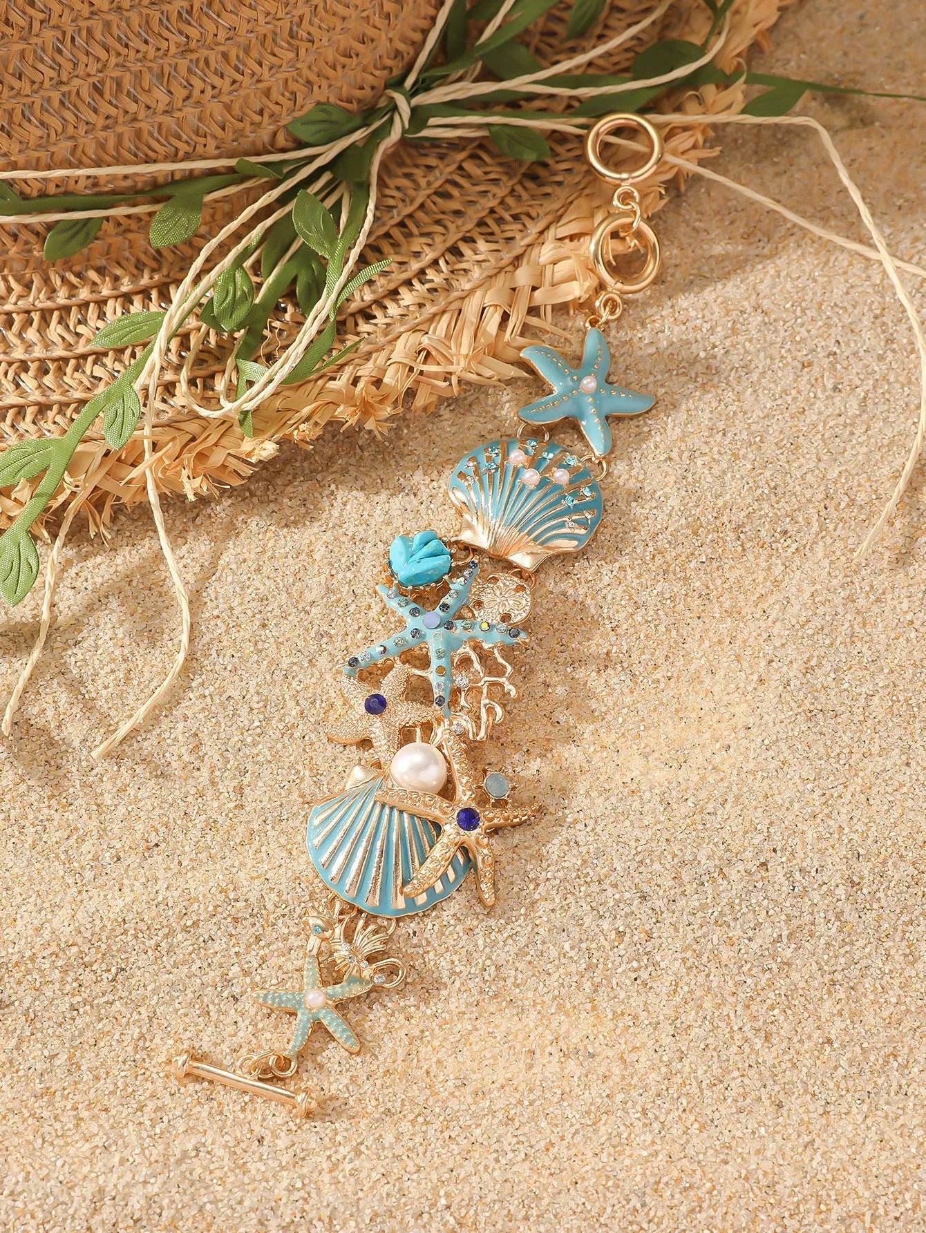Alloy rhinestone bracelet with boat anchor and starfish charm in turquoise, red, or blue.