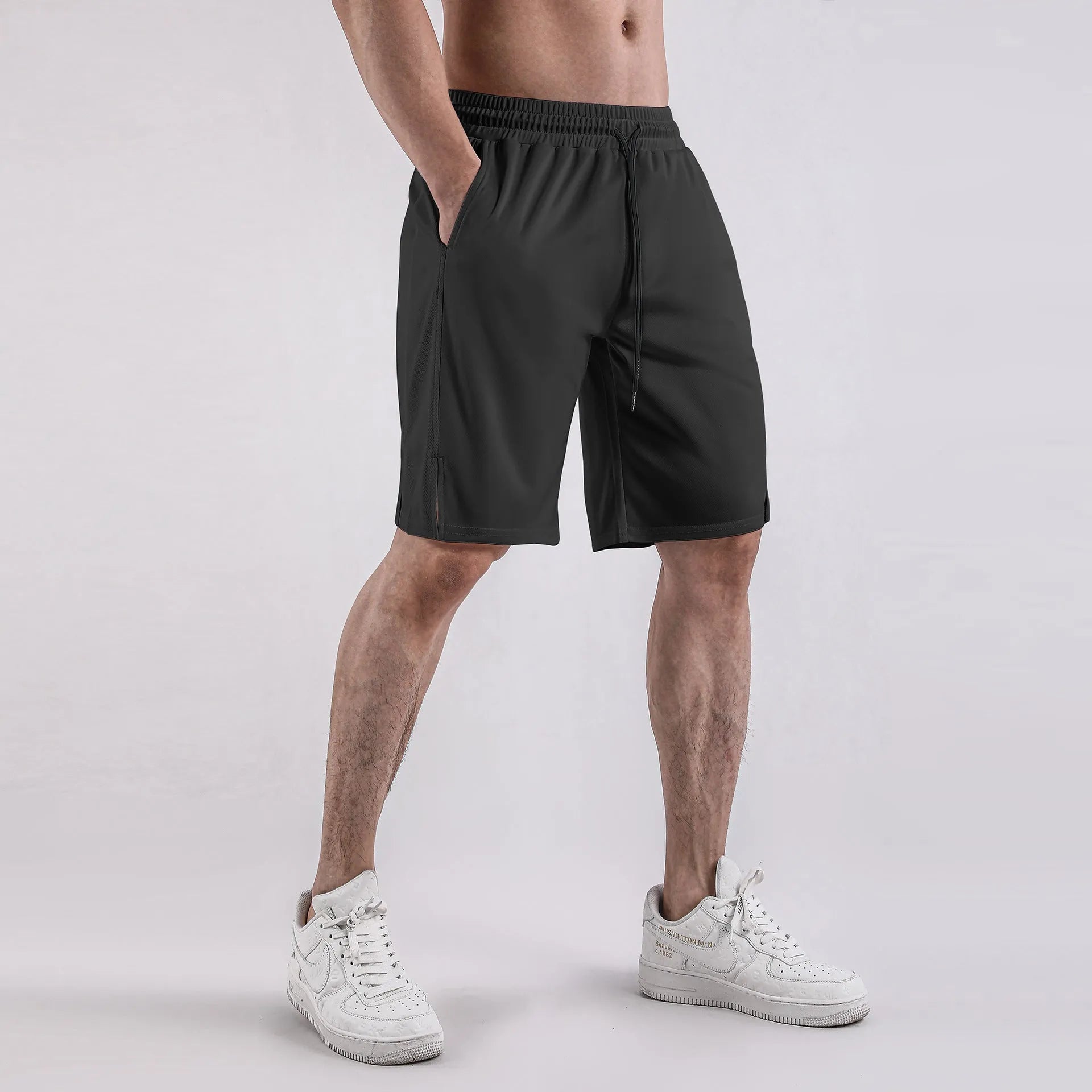 Men's black quick-drying mesh shorts in a loose capri length with elastic waistband.