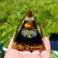 Small 6cm clear epoxy resin pyramid ornament with embedded pieces of natural coloured crystal gravel.