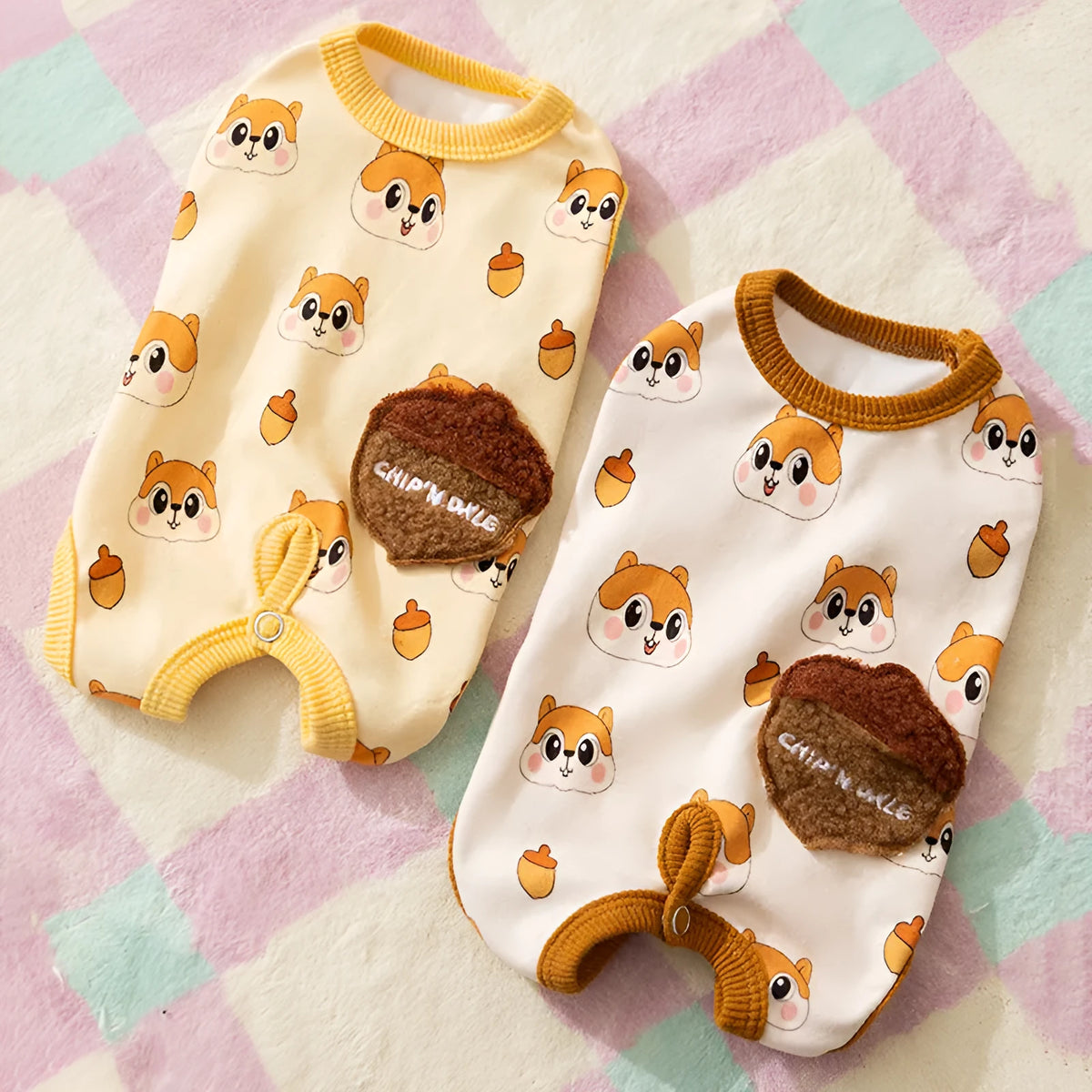 Chip 'n' Dale sleeveless dog jumpsuit with squirrel and acorn print, fuzzy embroidered acorn pocket, ribbed cuffs and snap closure, cream or white.