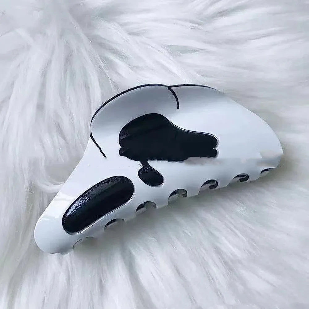 White plastic Halloween grimace barrette with 7 forks, 9.5x4x4.5cm, on white background